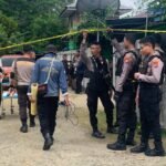 Aparat kepolisian mengamankan prosesi pembongkaran makam sebelum pelaksanaan autopsy terhadap jenazah Yahya Sayori di Reremi Puncak, Manokwari. Foto: AND