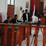 Terdakwa David Pata Saung membubuhkan tanda tangan usai sidang mendengar pembacaan putusan majelis hakim Pengadilan Tipikor Papua Barat pada PN Manokwari, Senin, 12 Agustus 2024. Foto: TIM2